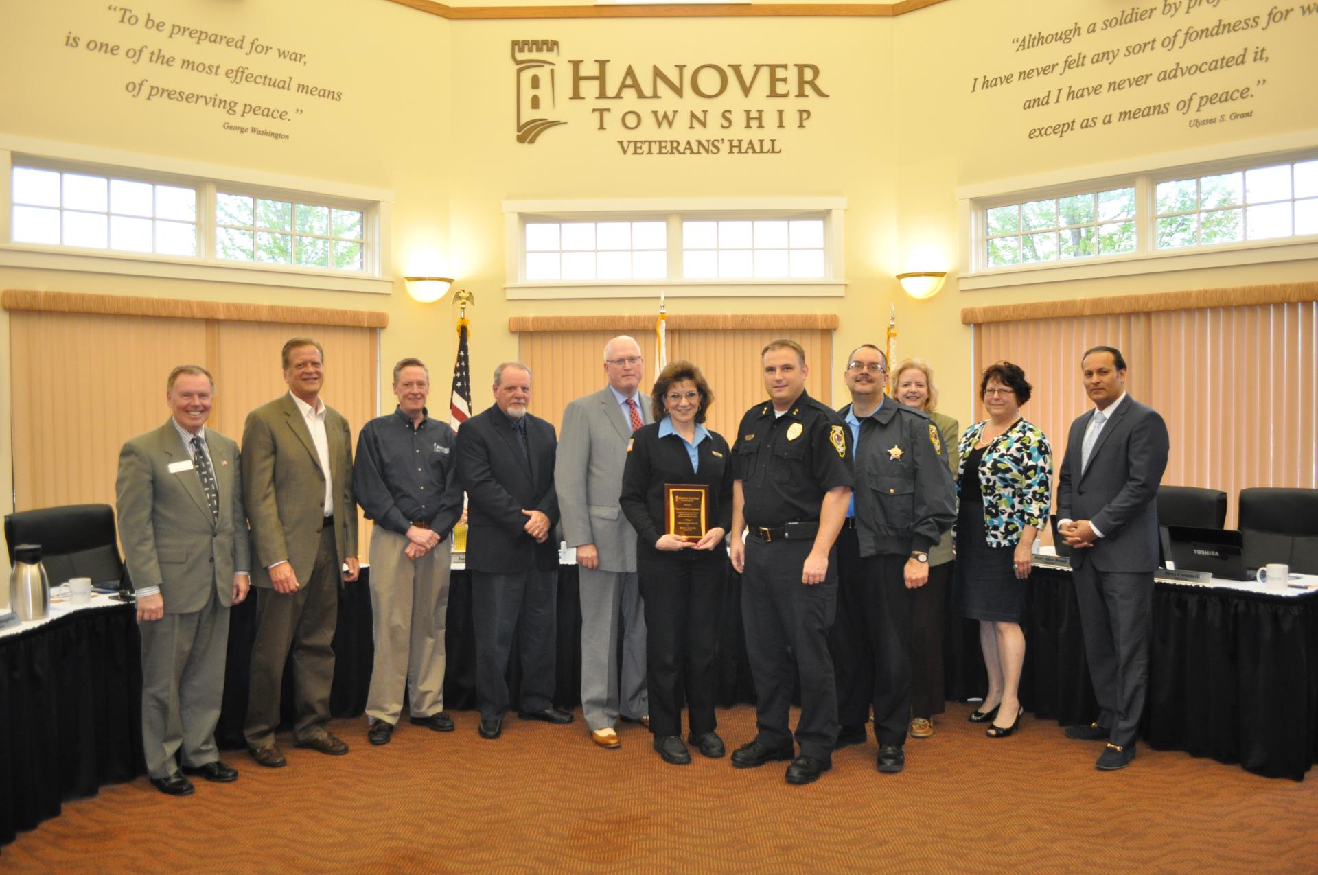 Six men and two women smile standing with three police officers.