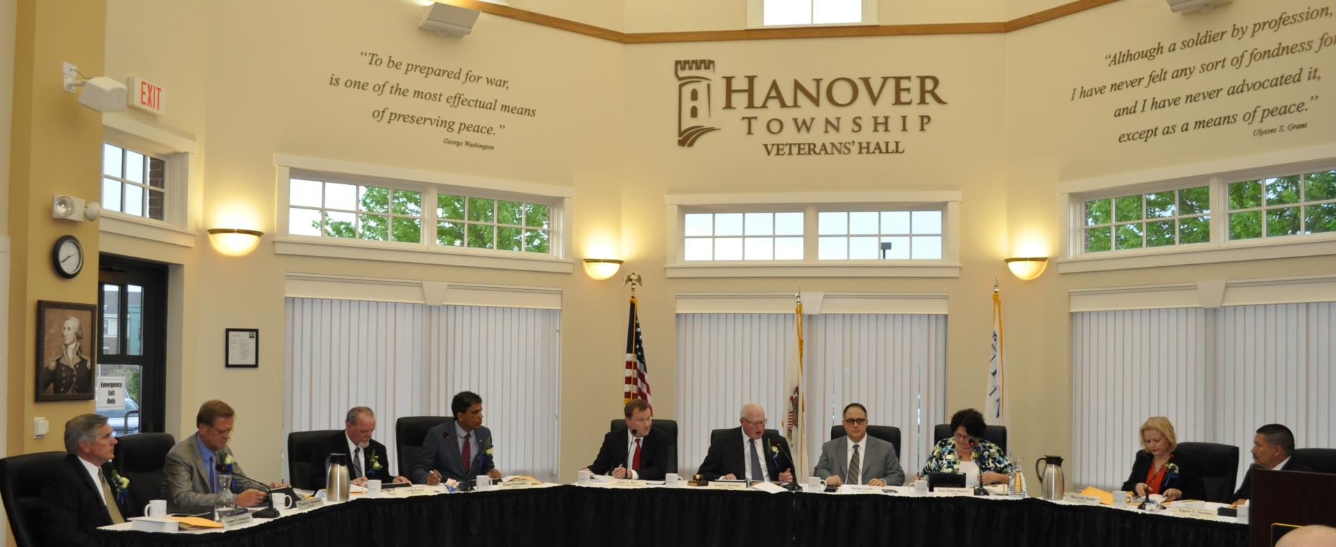 Seven men and two women sit around a table inside of Hanover Township Veteran's Hall.