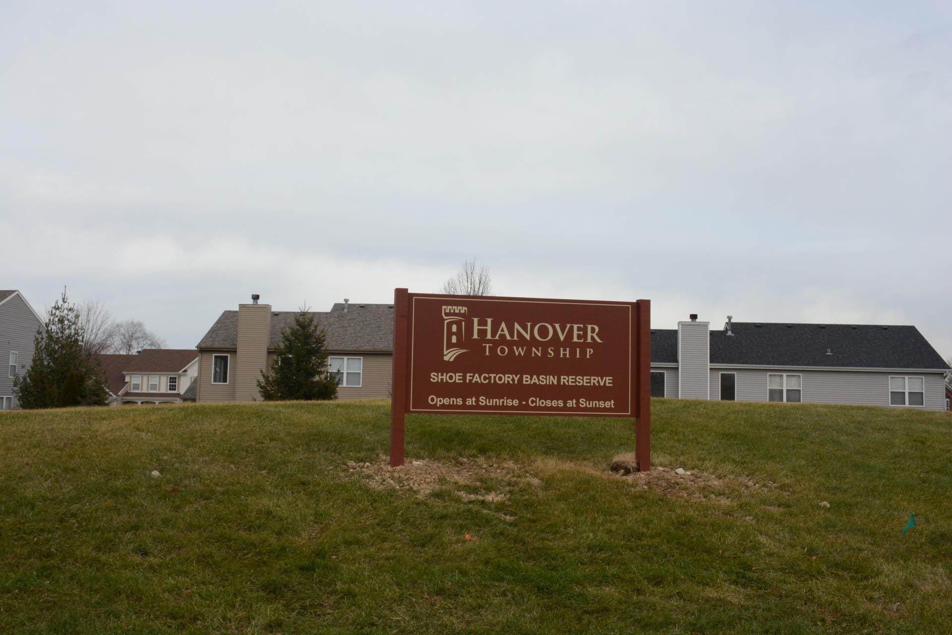 Maroon Hanover Township Shoe Factory Basin Reserve sign in front of homes on a cloudy day. 