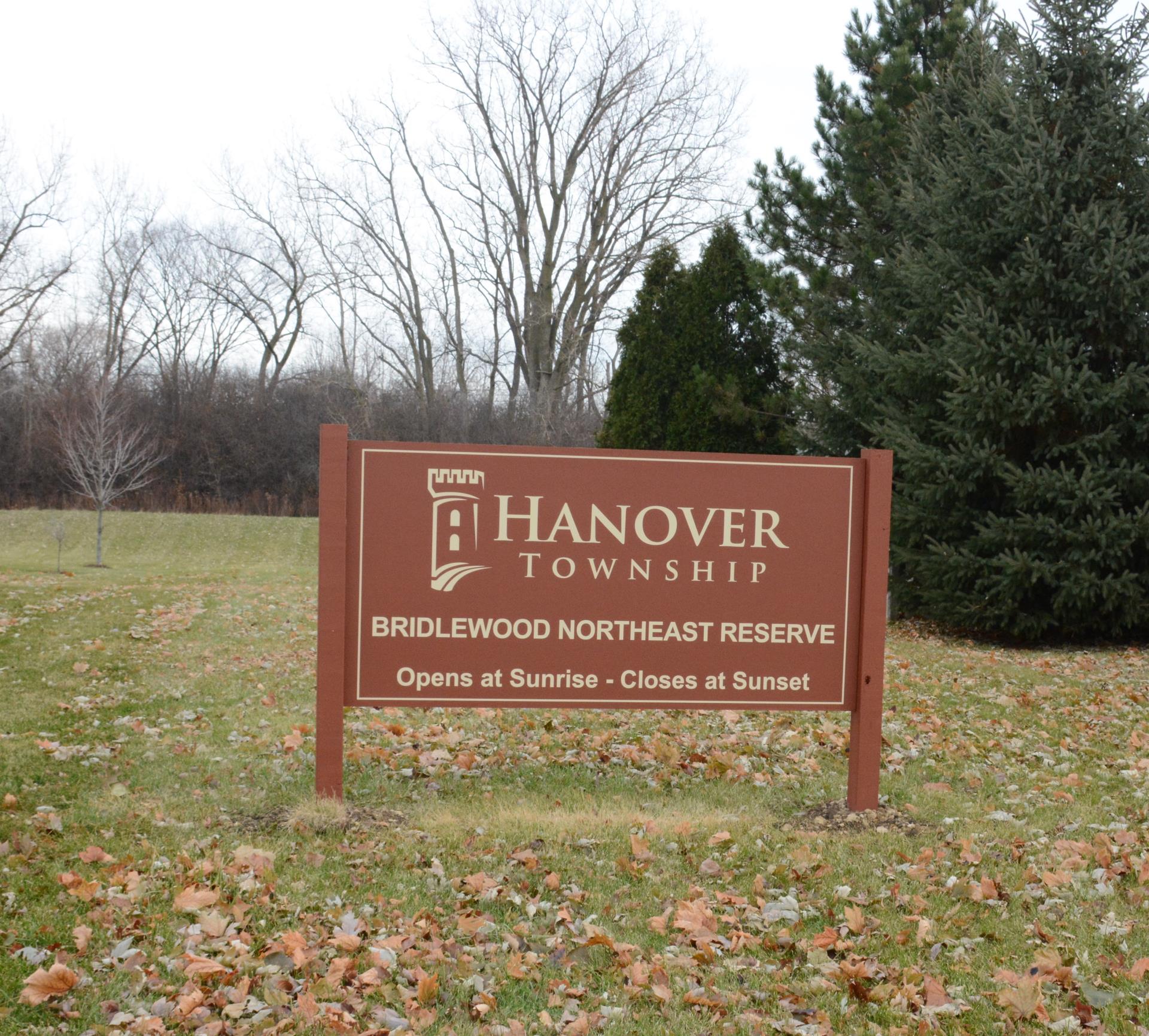 Maroon Hanover Township Bridlewood Northeast Reserve sign displayed in front of trees on a cloudy day. 