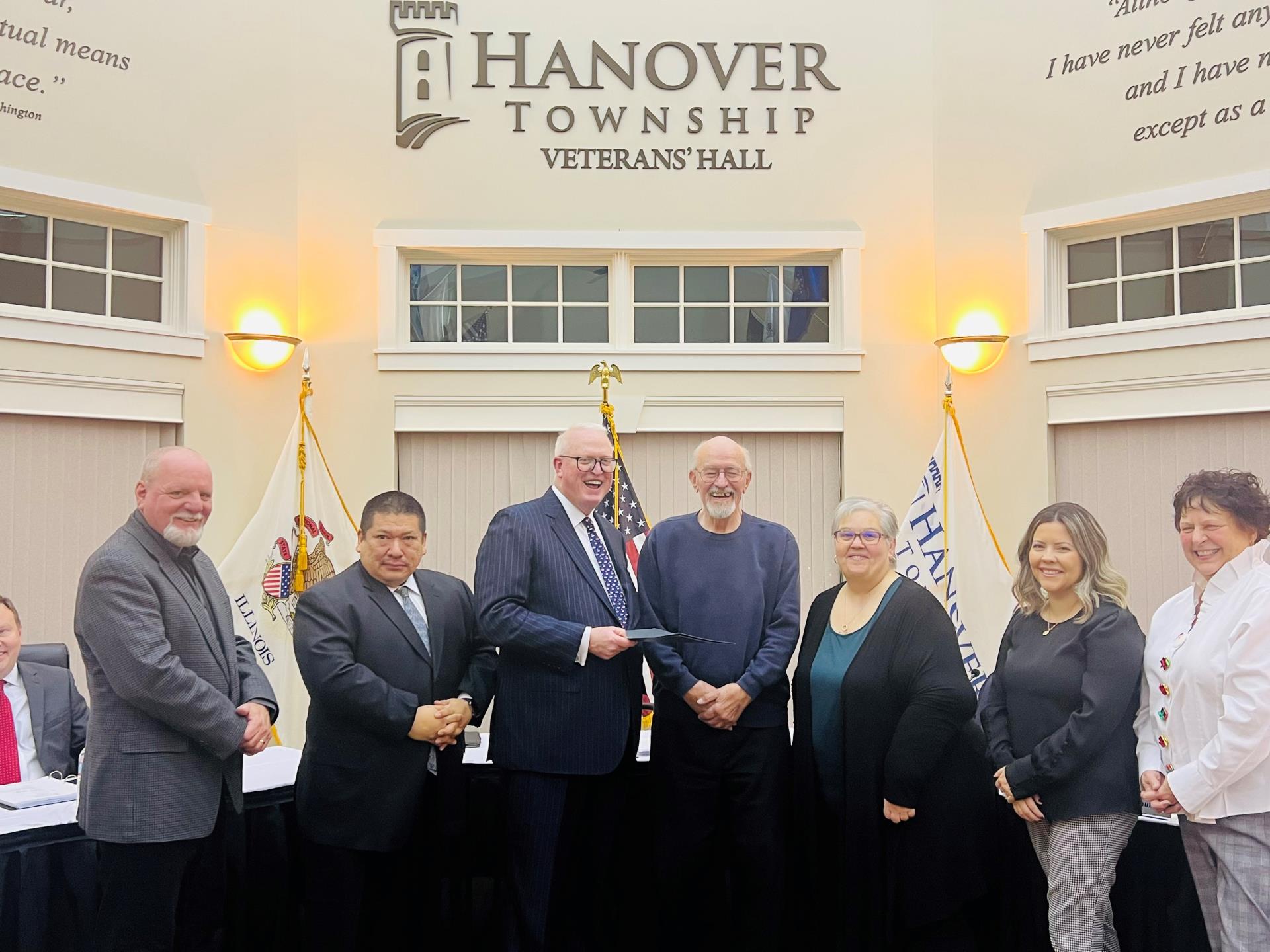 Hanover Township officials standing with a Veteran facing the camera while he holds his honor roll induction certificate.